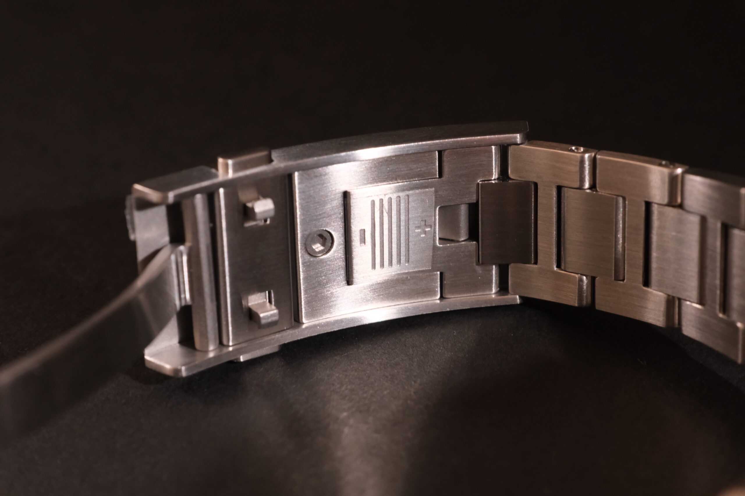 Close-up of a metal watch clasp with safety locks.