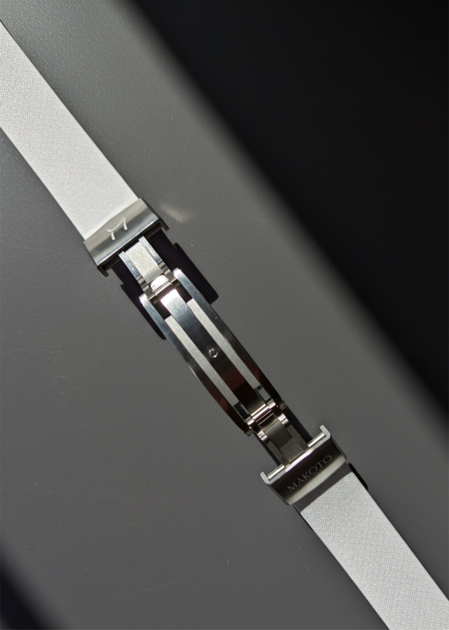 Close-up of a sleek metal watch clasp mechanism.