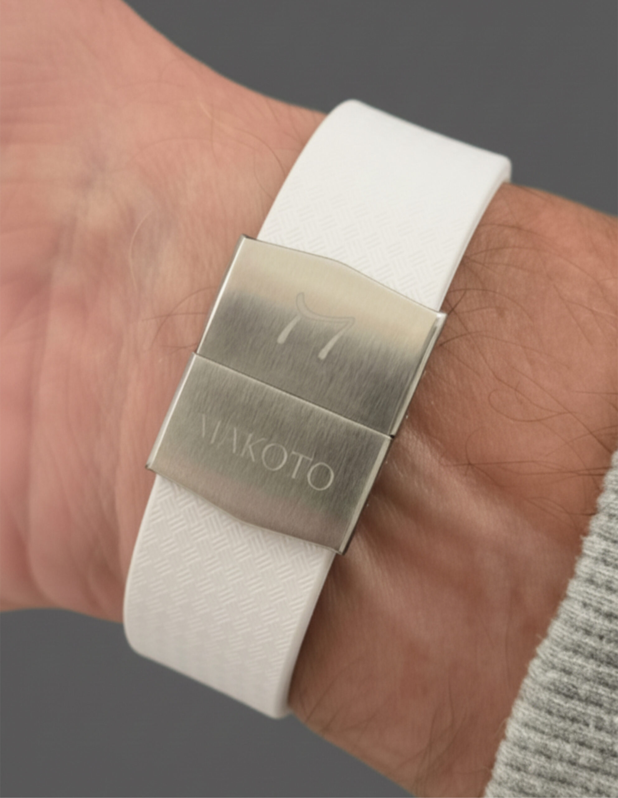 Close-up of a white wristwatch strap with a metal clasp.
