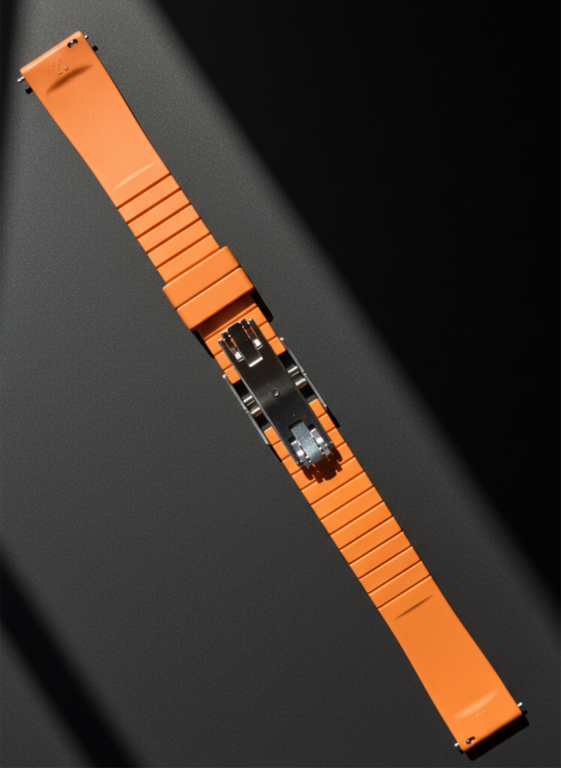 Close-up of an orange wristwatch with a transparent back revealing its mechanical movement.