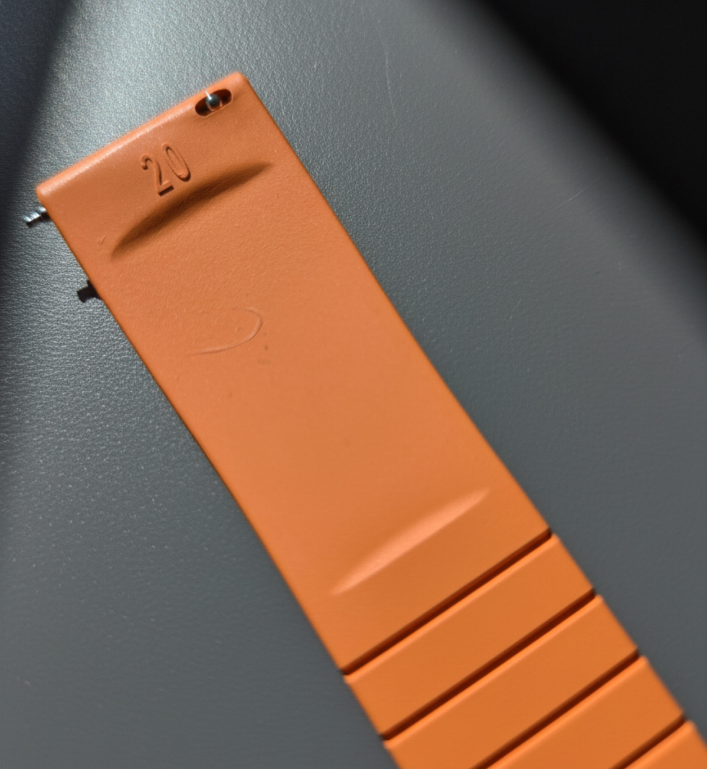 Orange leather phone case with camera cutout on a dark surface.