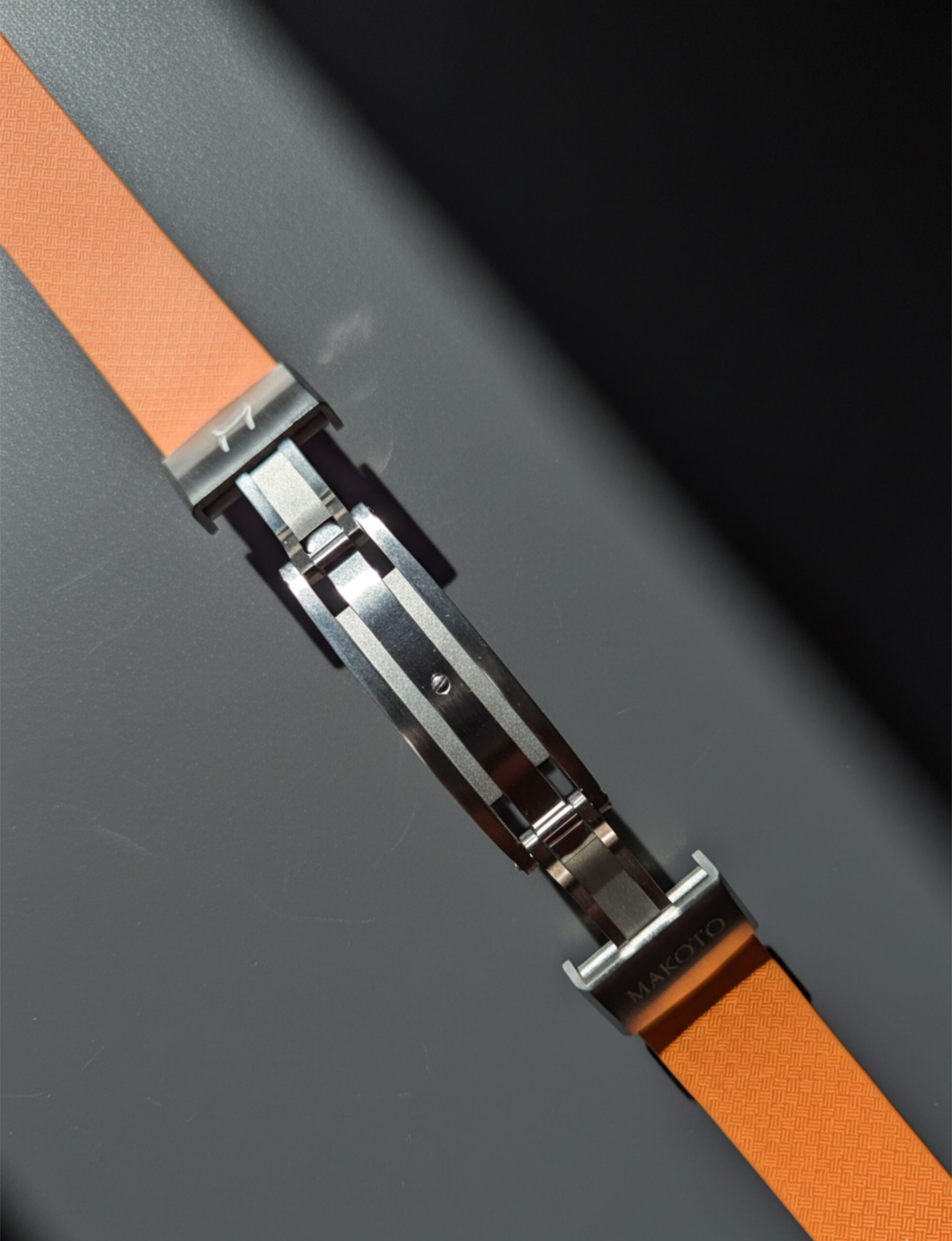 Close-up of a leather watch strap with a metal clasp mechanism.